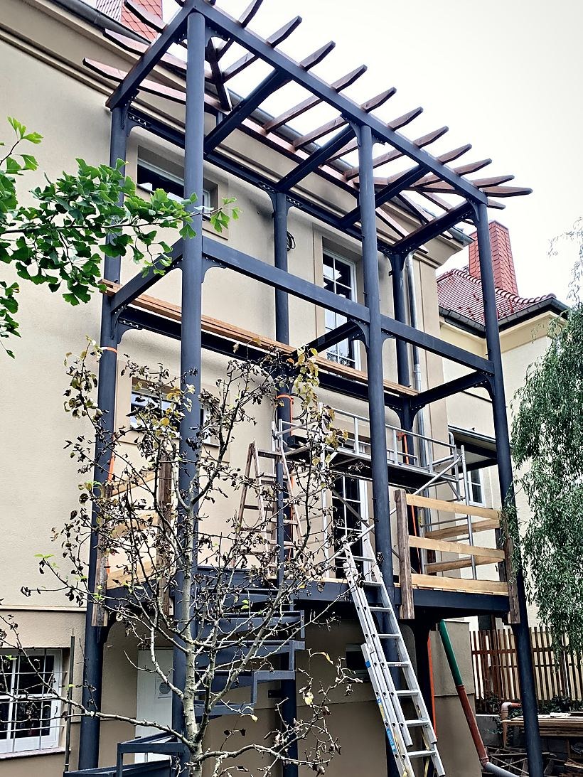 Mehrgeschossige Stahlkonstruktion mit Balkonen an einer Hausfassade
